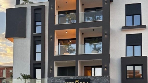 Un hôtel moderne, reconnaissable à son grand panneau « HERMOSA », doté d’une piscine et d’un espace extérieur bien entretenu.