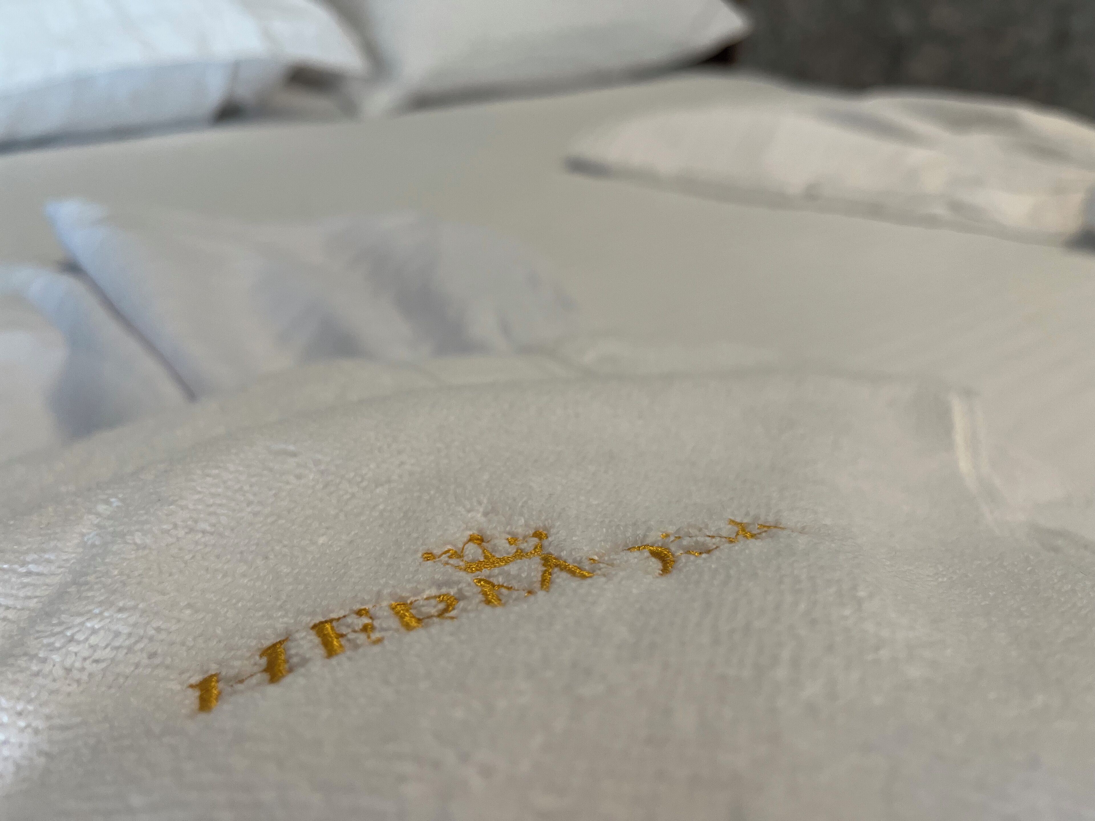 Un gros plan d’un oreiller blanc orné d’un texte brodé.
