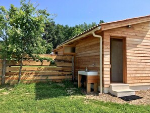 Una cabaña de madera con un baño pequeño, un lavabo y una puerta.