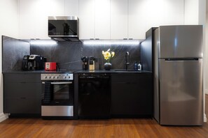 Enjoy cooking in this stylish kitchen with sleek cabinetry, stainless steel appliances, and a compact dishwasher.