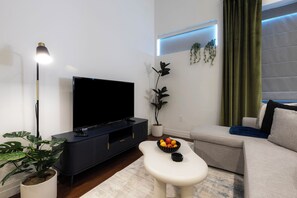 Relax in this stylish living room with a flat-screen TV, coffee table, and comfortable sofa.