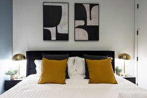 Relax in a serene bedroom with a large bed, two nightstands, and modern wall art.