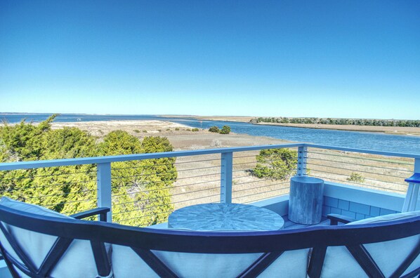 A balcony with a view of a river and distant shoreline.