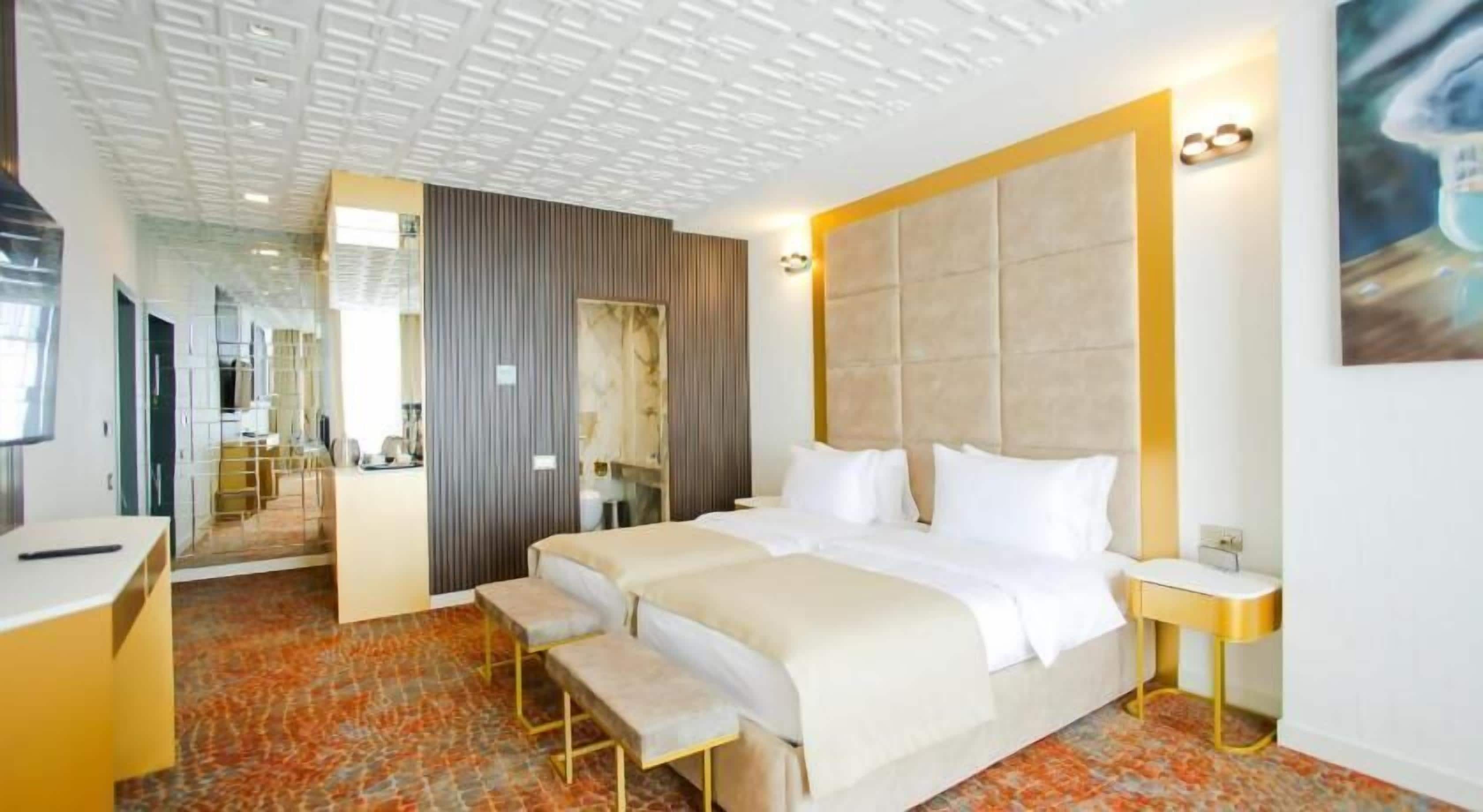 Una habitación de hotel con una cama grande, un escritorio y un espejo.