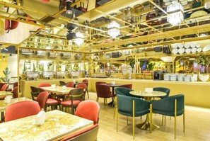 A restaurant with multiple dining tables and chairs, a bar area with a counter, and a ceiling with hanging lights. - Carat Hotel Yerevan (Yerevan)
