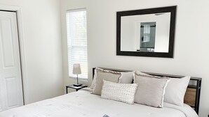 A neatly made bed with a white duvet, a folded towel, and a ceiling fan above. - The Haven Hideaway in Atlanta (Atlanta)