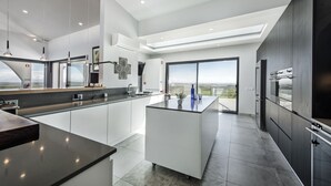 Una cocina moderna con una isla central, ventanas amplias y vistas al paisaje.