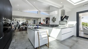 Una cocina moderna con una isla grande, armarios oscuros y un tragaluz.