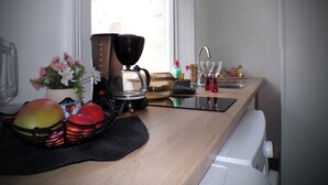 A kitchen counter with a coffee maker, a sink, and various kitchen items. - Apartmentsleeps4-west Kensington-petsok-parking (London)