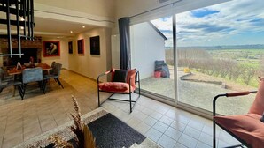 A spacious living area with a large window offering a view of the countryside.