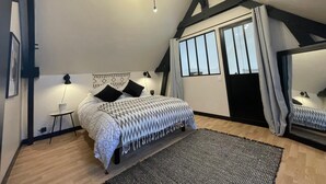A bedroom with a bed, a rug, a desk, a chair, a lamp, a window, and a ceiling light.