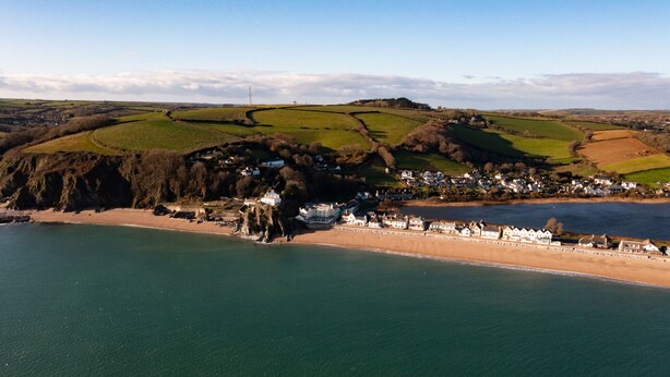 A coastal village with houses along the beach, a clear view of the sea, and rolling green hills in the background. - ​Beachfront Cottage with Sea Views & Coastal Walks​ (Torcross)