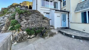A coastal building with a stone facade, a blue door, and a clear view of the sea. - ​Beachfront Cottage with Sea Views & Coastal Walks​ (Torcross)