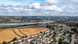 Een woonwijk met huizen, een rivier en velden.