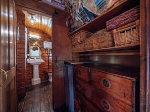 A compact wooden cabin with a small bathroom, a sink, and a dresser with drawers. - River View Apartment with Parking & Balcony (Dartmouth)