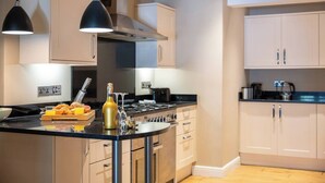 Une cuisine moderne dotée d’un îlot central, d’appareils électroménagers en acier inoxydable et de meubles de couleur claire.