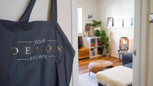A room with a bed, a chair, a bookshelf, and a plant.