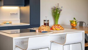 A modern kitchen with a white countertop, a coffee maker, a jar of jam, and a croissant on the counter. - Relaxed Devon Stay Close to fabulous Beaches (Slapton)