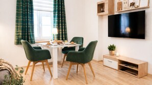A dining area with a table, chairs, and a TV mounted on the wall. - Nice vacation apartment near Pückler Park /pet friendly/ sauna in the house (Bad Muskau)