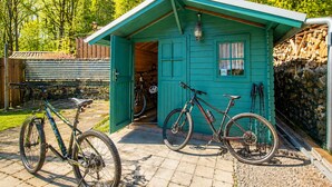 A small, green wooden shed with a door open, revealing a bicycle inside. - Quiet vacation apartment with two bedrooms Bad Muskau - Fürst Pückler Park (Bad Muskau)