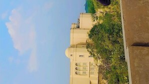 Une vue d’un bâtiment doté d’un grand dôme et d’une structure plus petite, percée de nombreuses fenêtres.