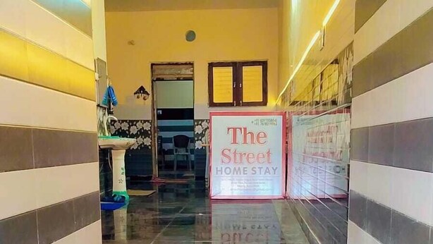 Un couloir doté d’un sol en marbre poli, de murs à rayures et d’une enseigne indiquant « The Street Home Stay ».