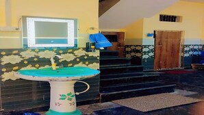 Une salle de bain avec un lavabo, un miroir et un escalier menant à une autre pièce.