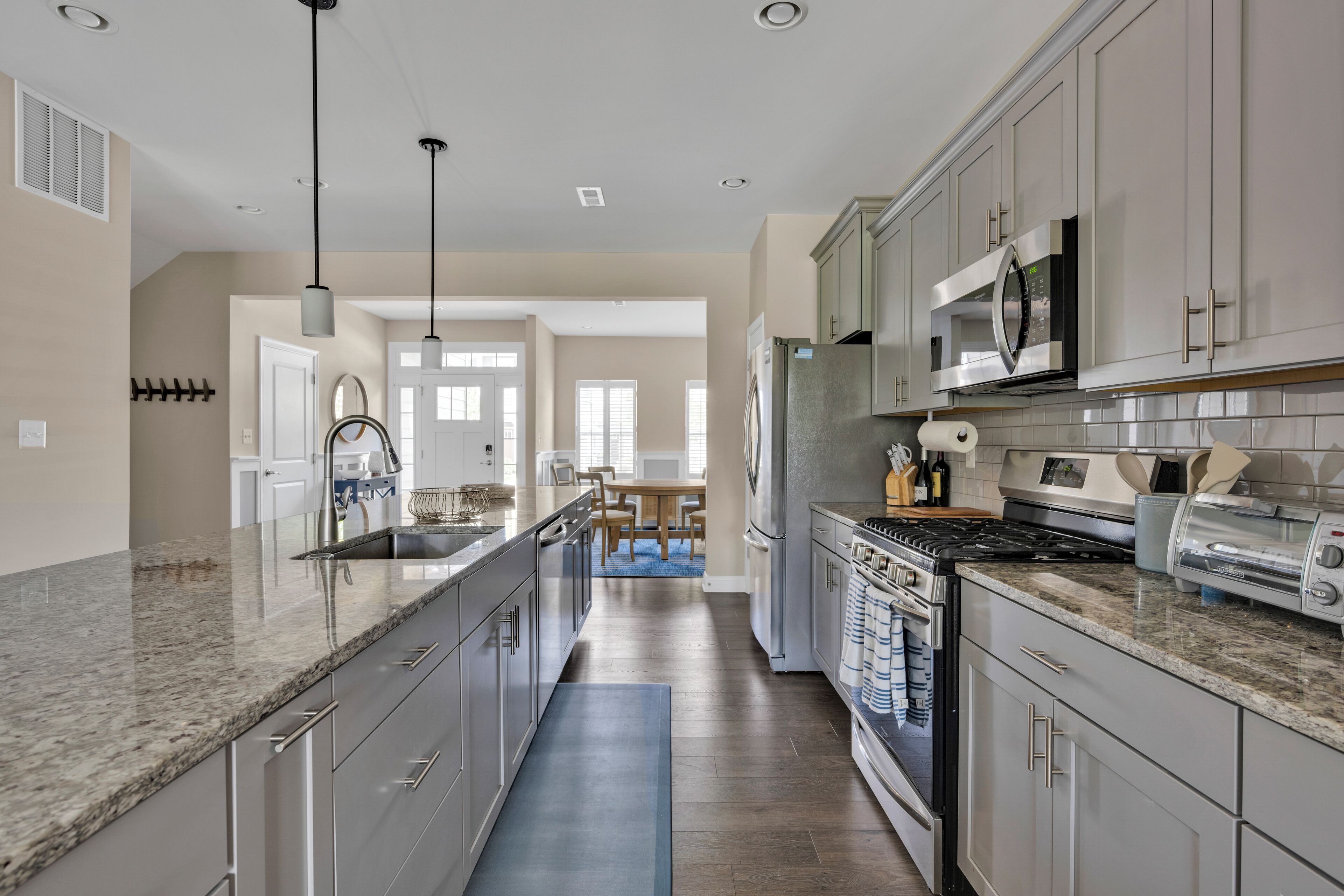A modern kitchen with granite countertops, stainless steel appliances, and a central island.