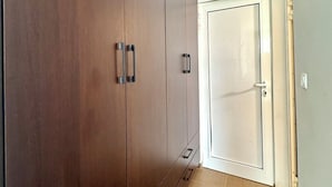 A hallway with a large wardrobe, a door, and a tiled floor. - Hotel Lobo (Budva)