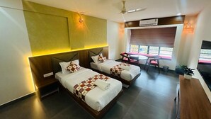 A modern hotel room with two beds, a desk, and a TV. - Maryland Residency (Sulthan Bathery)