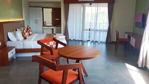 A hotel room with a bed, a desk, a chair, and a round table. - Maryland Residency (Sulthan Bathery)