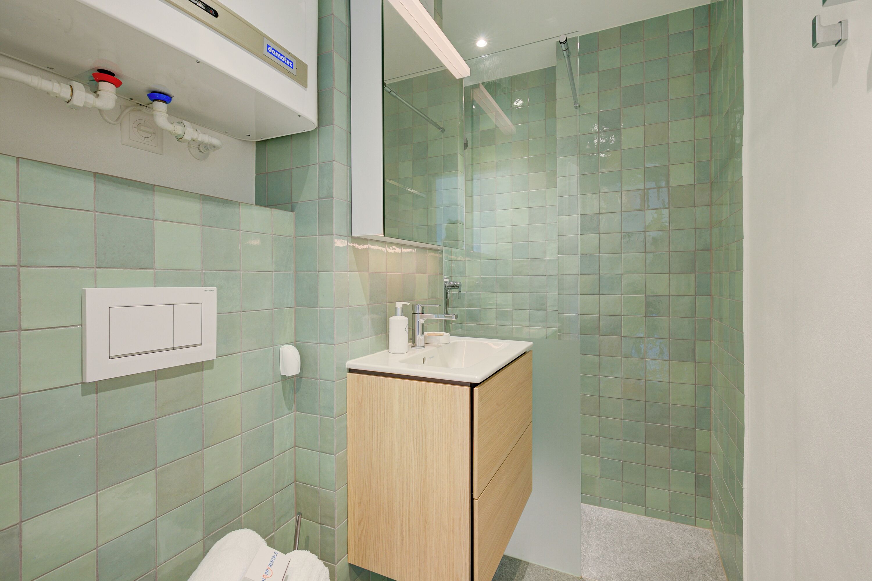 Un baño con un armario de madera, un lavabo y una cabina de ducha de vidrio.