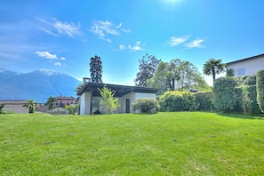 A house with a well-maintained lawn, a mountain in the background, and a clear sky. - Casa Miramonti Muralto (Muralto)