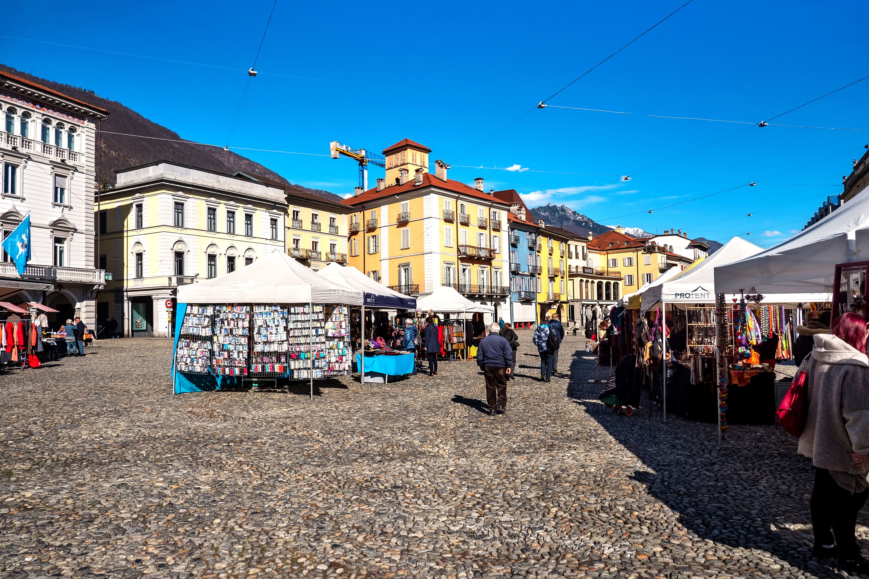 A cobblestone square with market stalls and historic buildings.