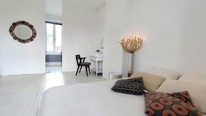 Une chambre à coucher moderne avec un grand lit, un bureau et une chaise.