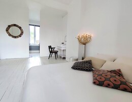 Un dormitorio moderno con una cama grande, un escritorio y una silla.