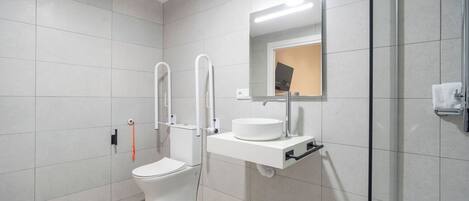Ein modernes Badezimmer mit Toilette, Waschbecken und Duschkabine.