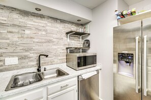 A modern kitchen with a stainless steel refrigerator, a built-in microwave, and a dish drying rack. - 4 Mi to Dtwn: Gem w/ Pool Access & Patio in Austin (Austin)
