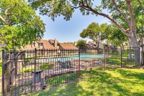 A fenced outdoor area with a pool, surrounded by trees and residential buildings. - 4 Mi to Dtwn: Gem w/ Pool Access & Patio in Austin (Austin)