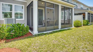 A modern two-story house with a covered patio area, a small garden, and a well-maintained lawn. - 7 Mi to European Village: Pond-front Townhome! (Palm Coast)