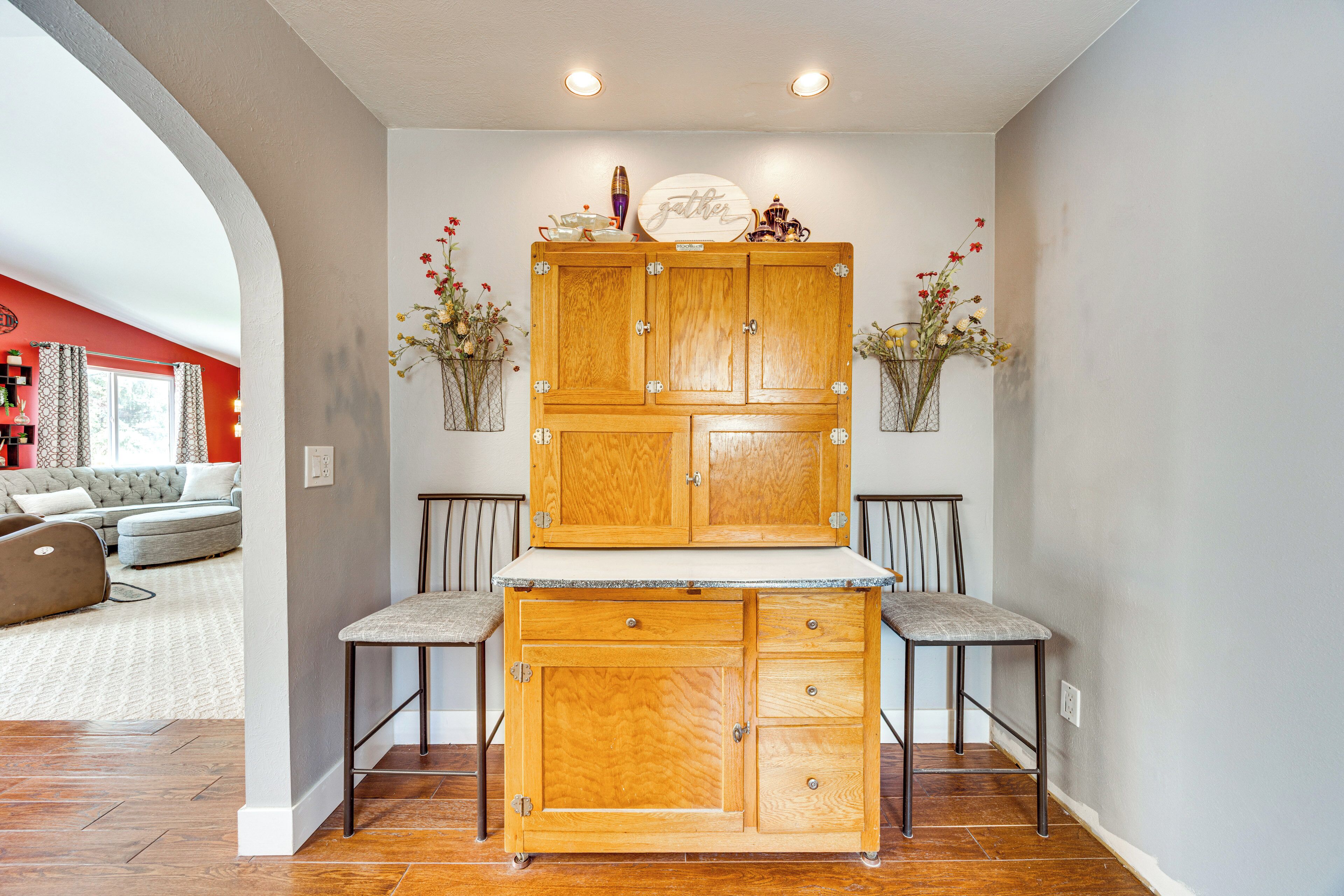 A kitchen with wooden cabinets, two bar stools, and a countertop.