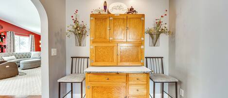 A kitchen with wooden cabinets, two bar stools, and a countertop.