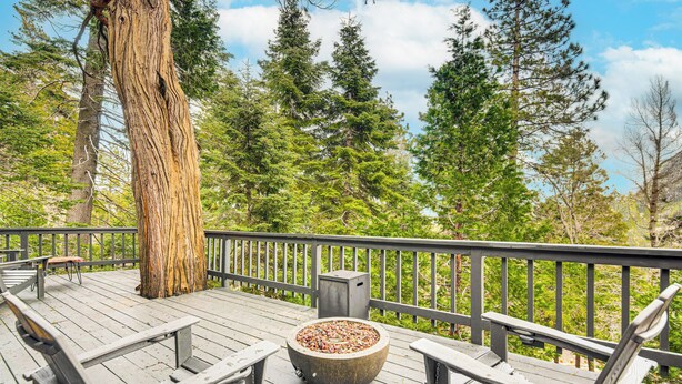 A wooden deck with benches and a fire pit, surrounded by tall trees and a clear sky. - 2 Mi to Lake Arrowhead: Treetop Retreat w/ Deck (Lake Arrowhead)