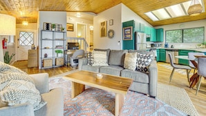 A spacious living area with a wooden ceiling, a grey sofa with patterned cushions, a wooden coffee table, and a colorful rug. - 2 Mi to Lake Arrowhead: Treetop Retreat w/ Deck (Lake Arrowhead)