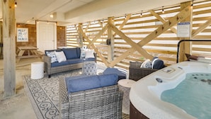 Ein Wellnessbereich mit Korbmöbeln, einer Whirlwanne und einer Holzterrasse.