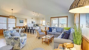 Ein geräumiges Wohnzimmer mit einer Couch, Sesseln, einem Couchtisch und einem Essbereich mit Tisch und Stühlen.
