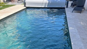 A rectangular swimming pool with clear water, surrounded by a tiled deck and outdoor furniture. - Contemporary home in Vaison-la-Romaine  Comfort, light & heated pool in Provence (Vaison-la-Romaine)