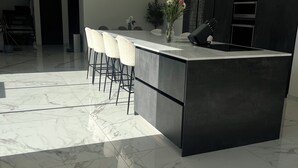 A modern kitchen with a marble floor, a central island with bar stools, and a built-in oven. - Contemporary home in Vaison-la-Romaine  Comfort, light & heated pool in Provence (Vaison-la-Romaine)
