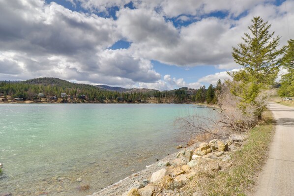 En klar sjö med en stenig strand och en väg som går längs med den.