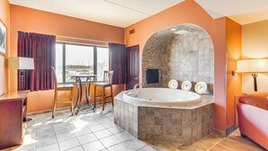 A bathroom with a stone-tub, a window with curtains, a desk, and a chair. - Chula Vista Condo: Resort Perks & Family Fun! (Wisconsin Dells)